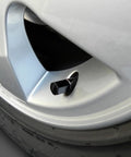 Close-up of a Black Tire Valve Cap with Permanent SS Logo, mounted on a car wheel, highlighting the durable ABS plastic material.