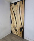 Handcrafted Live Edge Spalted Hackberry Barn Door With Custom Sizing Made To Order In Minnesota Totally One Of A Kind Rustic Modern Wood Door For Hallway Or Entryway, showing natural wood grain and dark maple frame.