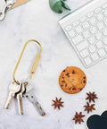 Brass Screw Lock Keyring Set Large Durable Screw Clip Carabiner For Handbags And Purses with keys on a desk