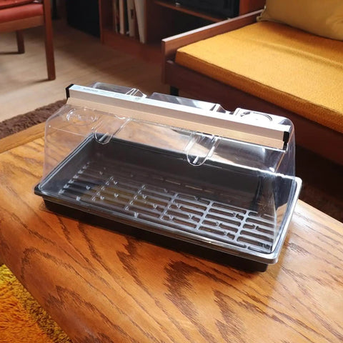 Prism Lens Powered LED Mini Greenhouse Kit With NanoTech Light Reflector And Double Thick Tray on wooden table.