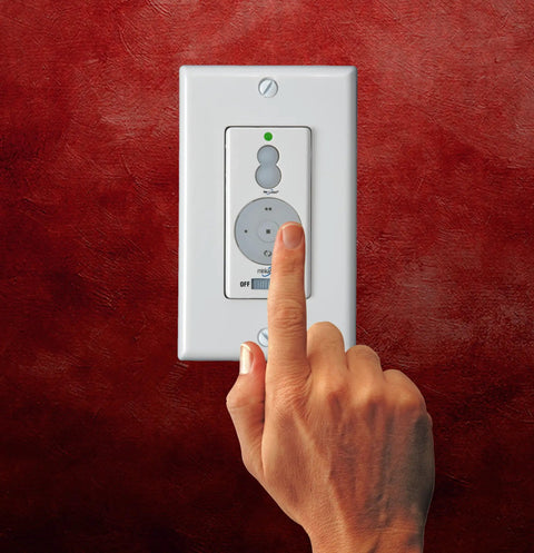 Hand operating the wall control of Aire Ceiling Fan With Full Function Wall Control For Easy Cooling, Traditional White And Gray Finish.