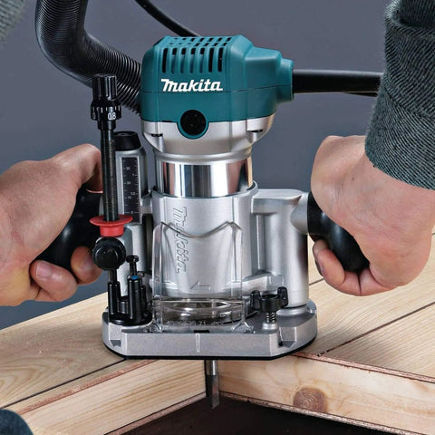 Close-up of a person using the Beefy One And One Quarter Horsepower Compact Router Kit With Variable Speed From 10000 To 30000 RPM Rack And Pinion Fine Depth Adjustment Slim Ergonomic Body And Quick Release Cam Lock For Precise Comfortable Woodworking on a wooden surface.