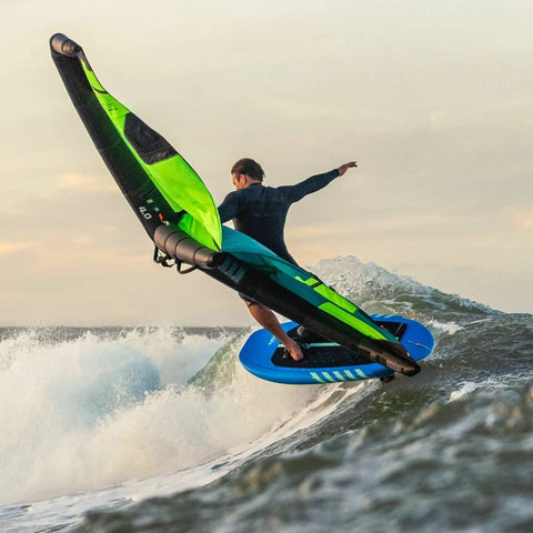 Rider using Wing Raider V1 Wing Foil Board 70 L on a wave, showcasing compact shape and V hull nose rocker for easy progression.