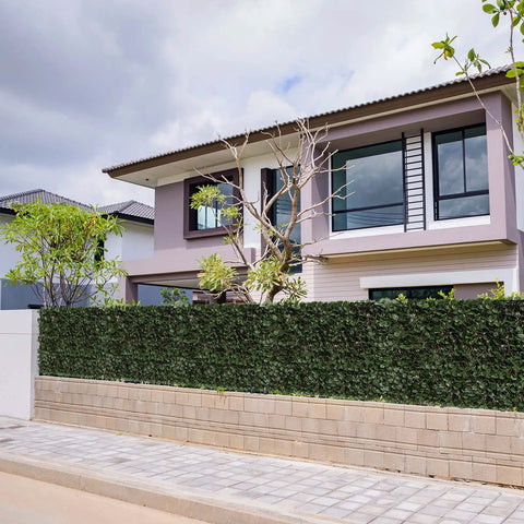 House with Expandable Fence Privacy Screen For Balcony And Patio With Double Sides Faux Ivy Fencing Panel Installed in front.