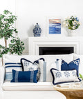 Coastal Navy Throw Pillow Cover 20x20 With White Embroidered Greek Key Frame on a white couch in a coastal-themed living room.