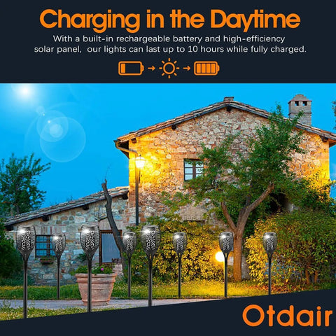 Outdoor Solar Torch Lights 96 LED Lit Dancing Flame 43 Inch Tall Waterproof Pathway Yard Garden Lamps Solar Powered With 2200mAh 6 Pack installed along a garden pathway at dusk, illuminating the area with a warm, candle-like glow.