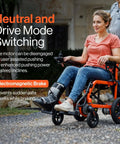 Woman seated in orange GoRide Series Lightweight Foldable Electric Wheelchair With Dual 250W Brushless Motors on sidewalk.