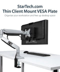Under Desk Thin Client Mount For Mini PCs And Docking Stations VESA Bracket Fits Mac Mini And Intel NUC Adjustable From 0.7 To 2.8 Inches Back Of Monitor Mount Keeps Cables Tidy And Frees Desk Space, shown on white desk with monitor and keyboard.