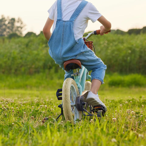Child riding a bike on grass with Kids 14 Inch Bike Tire and Inner Tube Set Heavy Duty 14x1.75 47 254 Tire visible