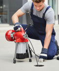 Man using Heavy Duty Electric Drain Snake With Seamless Auto Feed Cable And Beefy 500 Watt Motor on blocked drain.