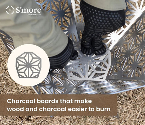 Portable Camping Fire Pit With Grill For Cooking being set up, showing sturdy steel design with charcoal boards on grass.