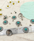 Straight Fire Green Turquoise Concho Buttons 10 Pack With Screw Back Fasteners arranged on fabric with ruler and flowers.