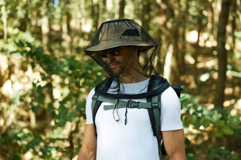 Individual wearing Two Pack Mosquito Head Net Mesh For Hiking And Outdoors Over Hat in a forest setting