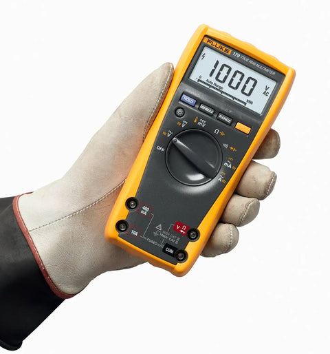 Person holding Pro Grade True RMS Digital Multimeter with Backlit Display and Built-In Temperature Probe, close-up view.