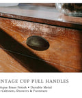 Antique Brass Cup Pulls Eight Pack With Two And A Half Inch Hole Centers Vintage Bin Style Cabinet Handles on wooden drawer.