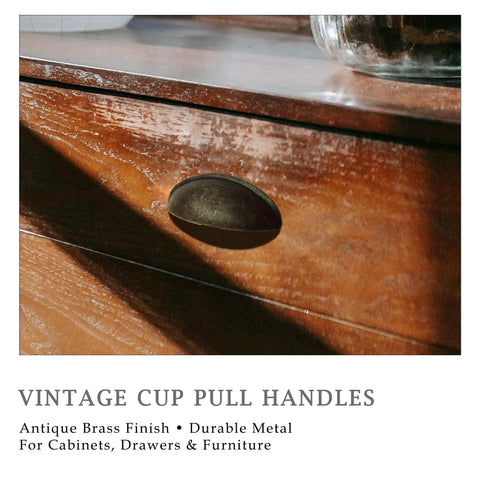 Antique Brass Cup Pulls Eight Pack With Two And A Half Inch Hole Centers Vintage Bin Style Cabinet Handles on wooden drawer.