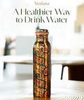 Copper Water Bottle 1 Liter With Ayurvedic Health Benefits displayed on a wooden table in a bright setting.