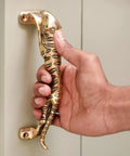 Man holding Vintage Style Interior Door Pull Handle 1 Piece in Antique Brass and Gold Finish Rust-Resistant Cabinet Pull for Doors and Furniture Easy Installation with No Sharp Edges Safe for Homes and Offices
