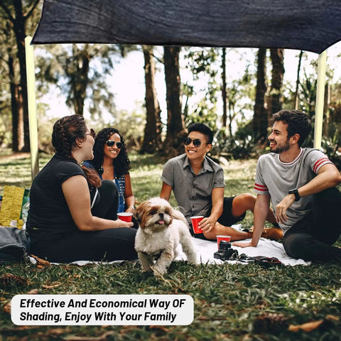 Group of friends and a dog sitting under a 55 Percent Shade Cloth Mesh Tarp With Grommets For Plant Cover 6.5X16.5Ft
