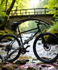 Black mountain bike with "Beef Up Your Ride With This 190mm Black Bike Axle For Rear Hub Three Eighths Inch 26 TPI Shaft Conical Lock Nut Washer Kit Steel Hub Accessory For Wheels And Cycling Ideal For Multi Speed Rigs On Street Mountain Or City Bikes" displayed near a river.