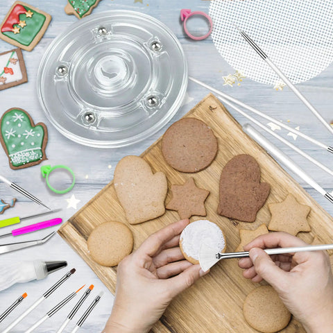 Badass 112 Piece Baking Decorating Kit With Sturdy Acrylic Turntable and decorated cookies on a wooden board.