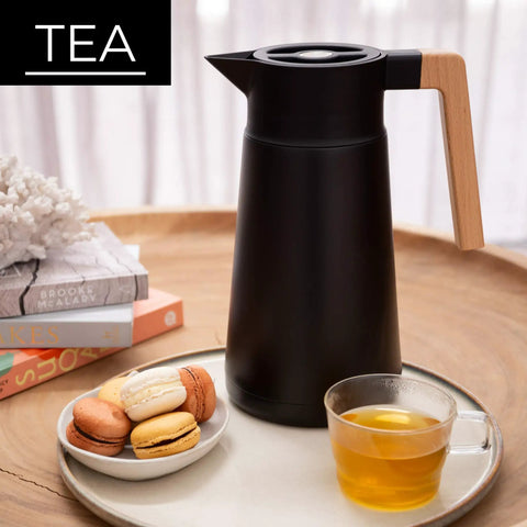 68 Oz Stainless Steel Insulated Coffee Carafe With Tea Infuser And Strainer 2 Liter Double Wall Vacuum Thermal Dispenser For Hot Or Cold Beverages Keeps Brew Fresh For Hours Black, sitting on tray with tea and macarons