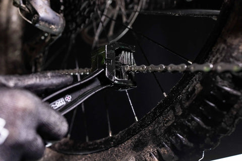 Go To Road Gravel MTB Bicycle Chain Cleaning Brush Three Sided Tool With Long End being used on a dirty bike chain