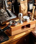 Kickstart Your Morning Routine With This Boss Level Espresso Tamping Station Featuring True 58Mm Calibration And Gorgeous Reclaimed Wood Tray To Slick Out Your Everyday Coffee Bar Setup on a wooden countertop with barista tools.