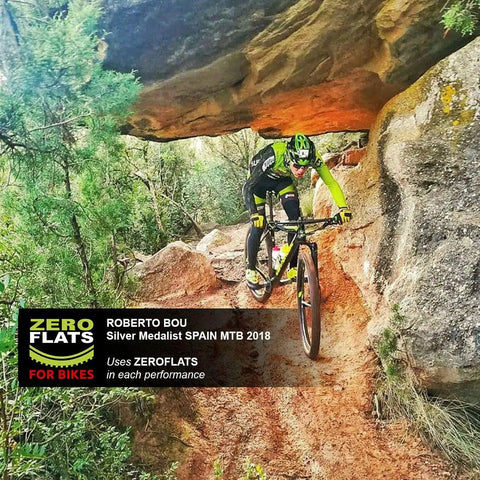 Mountain biker on a rocky trail using Anti-Puncture Bike Tire Sealant, 8.45oz, Ultra-Fast Liquid For Standard, Tubeless And Tubular Tires