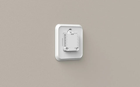 Mounted white Large Cover Plate And Electrical Box Adaptor For T Series Thermostats on beige wall