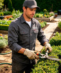 Mens Heavy Duty Mechanic Work Shirt With Custom Crew Logos Heavyweight Cotton Twill Button Up Long Sleeve Trade Ready Uniform worn while trimming hedges.
