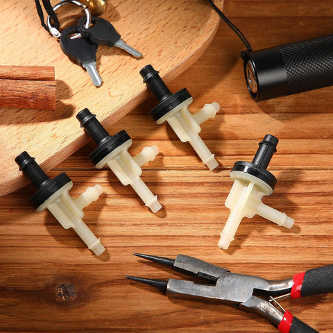 Top-down view of four beige plastic vacuum check valves with black tops for automotive vacuum lines.