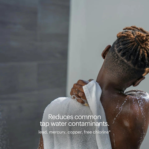 Back view of person using towel in shower, emphasizing cleaner water from compact shower filter