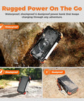 Rugged Beast Power Bank 20000mAh with built-in cables and wireless Apple Watch charger on a rocky outdoor surface.