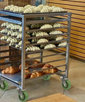 Bakery rack with croissants on high temp oven caster wheels for smooth transport in industrial kitchens.