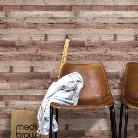 Cinnamon Wood Peel And Stick Wallpaper Self Adhesive Faux Wood Plank behind brown chairs, measuring tape, and shopping bag