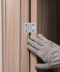 Person installing Mini Folding Hinges for Small Cabinets and Wooden Boxes 4 Pack Zinc Alloy 180 Degree Black Uxcell 43mm by 58mm 7mm Thick Adjustable on cabinet