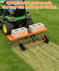 40-Inch Tow Behind Dethatcher With 20 Rust-Proof Tines in use on grass, attached to lawn tractor with 70 lbs weight on tray.