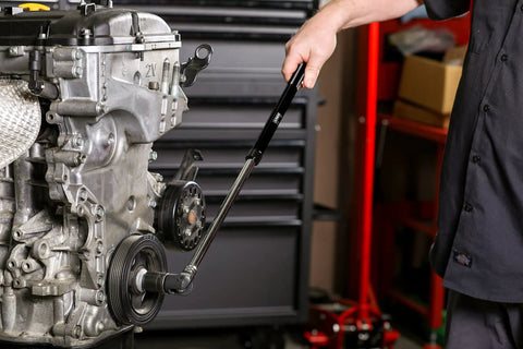 Mechanic using Extendable 1/2 Inch Drive Black Breaker Bar With Twist Lock Telescoping 16 To 24 Inch Reach on engine bolt