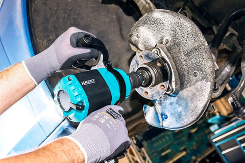 Tough As Nails Twin Turbo Air Impact Wrench With Compact Low Vibration Grip For Tightly Packed Engine Bays And Heavy Duty Truck Maintenance in action on a vehicle's wheel hub.