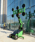 Rock Solid Heavy Duty Glass Vacuum Lifter Robot For No Sweat Heavy Panel Grip And Slick Curtain Wall Installation With Fully Custom Config Options For Pro Teams beside a worker installing glass.