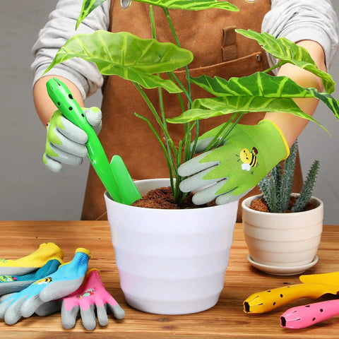 Child using 24 Piece Kid Friendly Garden Tool Set With Mini Colorful Metal Shovels And Gloves Includes 12 Hand Trowels In 6 Colors And 12 Pairs Of Garden Gloves Ideal For Little Gardeners 11 By 3 Inch Shovels to plant in a white pot