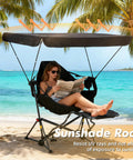 Woman relaxing in Portable Folding Hammock Camping Chair With Canopy And Footrest on beach, reading under adjustable shade