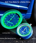 32nds Tire Tread Depth Gauge with Glow In The Dark Luminescent Dial on ground near car, metal casing visible