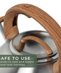 Close-up of Stovetop Whistling Tea Kettle Two Point Four Quart Stainless Steel For Induction And Gas Stovetops with wood-look handle.