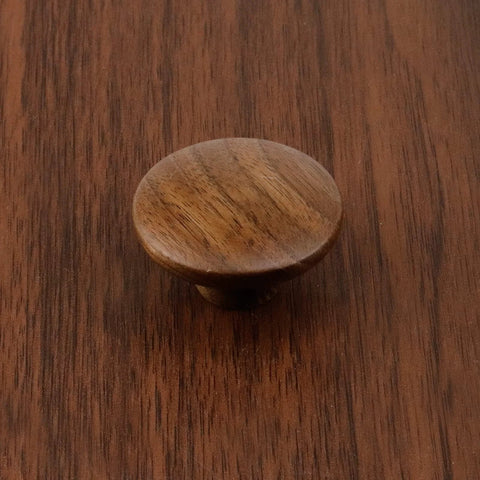 Round walnut wood cabinet knob on surface, part of 10 Pack Round Walnut Wood Cabinet Knobs With Screws 1.57 Inch Diameter Ideal For Cabinets Dresser