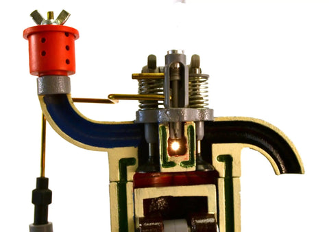 Close-up of Hands On 4 Stroke Diesel Hand Crank Engine Model For Education showing crankshaft and glow plug parts