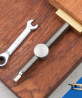 Heavy Duty Adjustable Benching Dog Clamp For Woodworking, Three Quarter Inch Dog Hole Clamp with wrench on wood surface.
