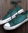 Green canvas shoes with white rubber soles on wood background, featuring metal eyelets from the 100 Piece Grommet Kit Metal Eyelets Set For Shoes Clothes Belts Bags DIY Projects 3mm Inner Hole One Eighth Inch Gold Tone Iron Rust Proof Durable Washer Included.
