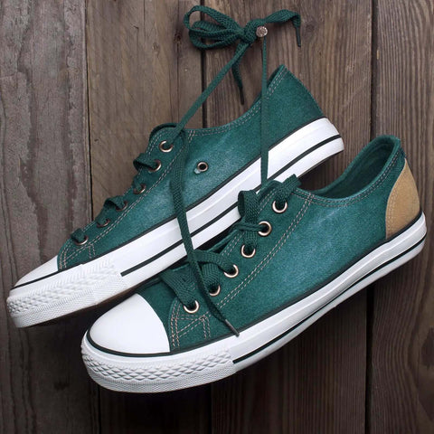 Green canvas shoes with white rubber soles on wood background, featuring metal eyelets from the 100 Piece Grommet Kit Metal Eyelets Set For Shoes Clothes Belts Bags DIY Projects 3mm Inner Hole One Eighth Inch Gold Tone Iron Rust Proof Durable Washer Included.